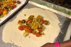 starting to fill pastry with burst tomatoes