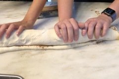 rolling up cinnamon rolls