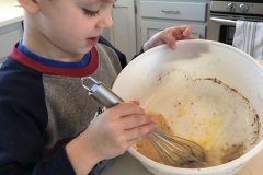 Sprinkling cinnamon and sugar with gusto for cinnamon pinwheels.